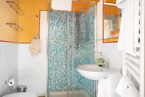 Un baño con lavabo y ducha de cristal. en La Corte di Langa alloggio Quarzo, en Albaretto Della Torre 