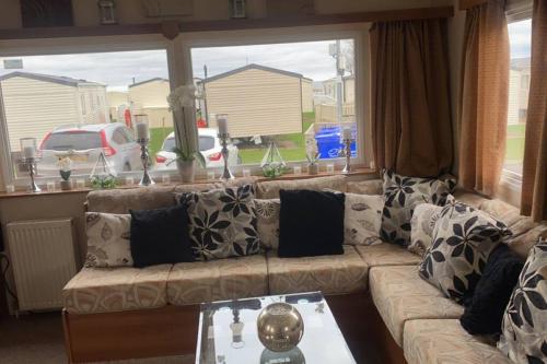 a living room with a couch and a large window at Whitley bay caravan retreat in Whitley Bay