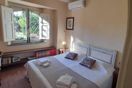 a bedroom with a large white bed with two pillows at La Casetta Rosa alloggio indipendente, four beds in Mascalucia