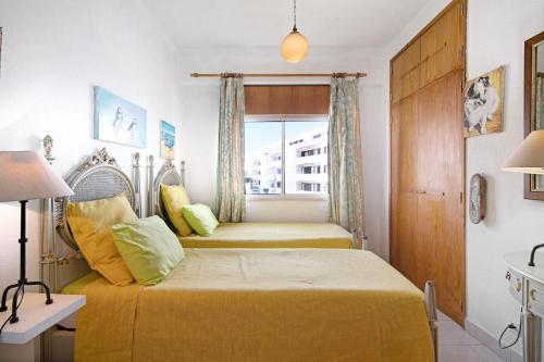 a bedroom with two beds and a window at T3 Duplex Albufeira in Olhos de Água