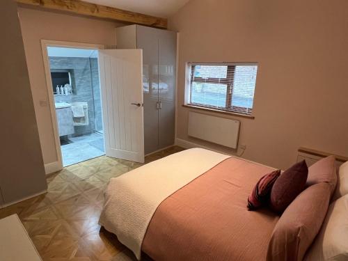 a bedroom with a bed and a bathroom at Penburren at Minster Farm West in Hereford