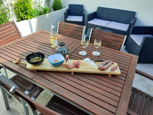 馬洛塞納的住宿－location à Malaucène，一张木桌,上面放着一盘食物和酒