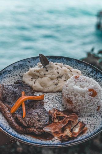 a plate of food with rice and vegetables on a table at Pousada Serra&Mar Angra dos reis in Angra dos Reis
