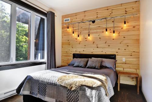 Un dormitorio con una pared de madera y una cama en Chalets Alpins -13 Chemin des Skieurs, en Stoneham