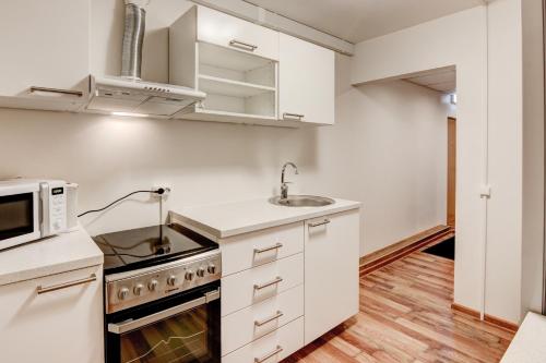 a kitchen with white cabinets and a microwave at Smolensko st 13 Vilnius Students Home LT in Vilnius
