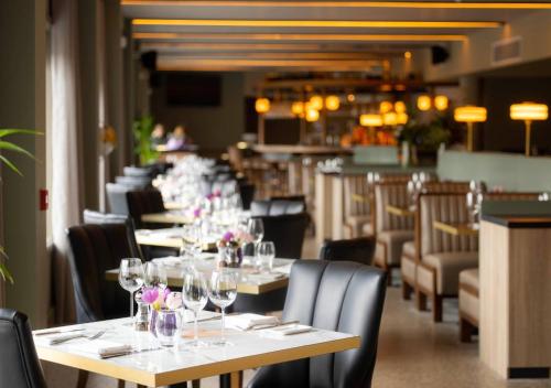 a dining room with tables and chairs with wine glasses at The Club at Goffs 