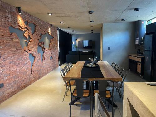 a dining room with a table and a brick wall at Loft 1930 in Villa Carlos Paz