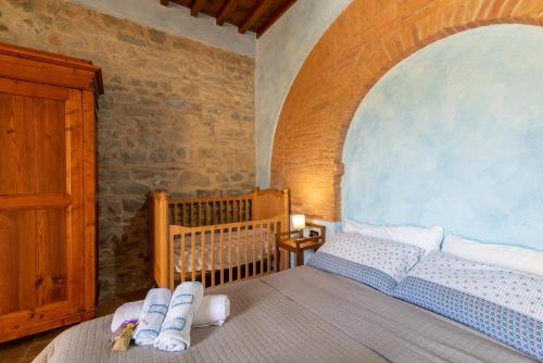 1 dormitorio con cuna y 1 cama con toallas en Appartamento Cantina al Bellini, en Pulicciano
