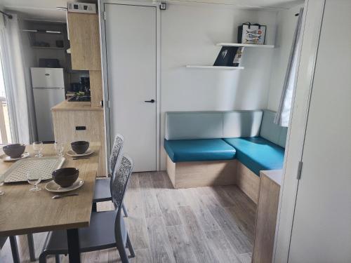 une petite cuisine avec une table et un banc bleu dans l'établissement La cabane de la falaise, à Narbonne