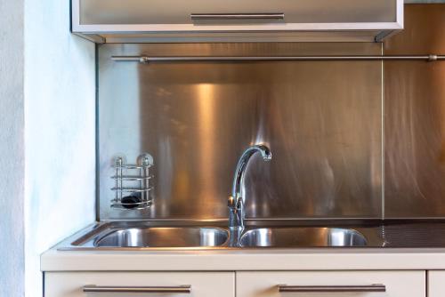 um lavatório de cozinha em aço inoxidável com uma torneira em Appartamento Cantina al Bellini em Pulicciano