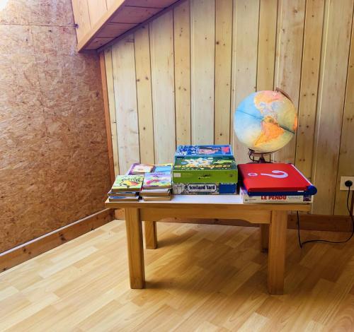 a table with books and a globe on it at Maison chaleureuse à Vaucluse avec jardin spacieux 84 m² in Vaucluse