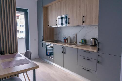 a kitchen with white cabinets and a sink and a table at Your New and Modern Home in Bucharest