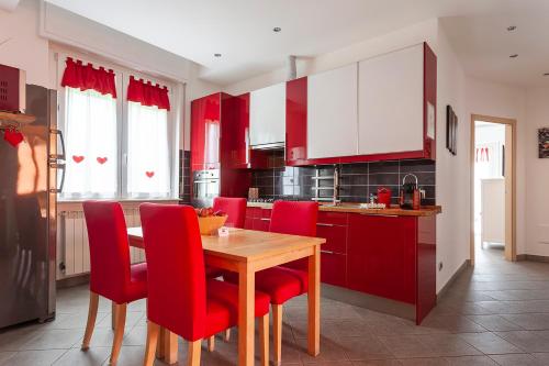 a kitchen with red chairs and a wooden table at Malpensa Garden in Case Nuove