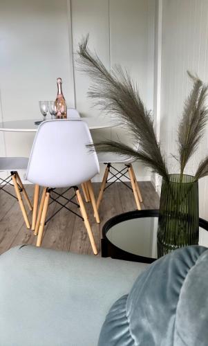 a living room with a white chair and a table at Ironland Roztocze in Ruda Żelazna