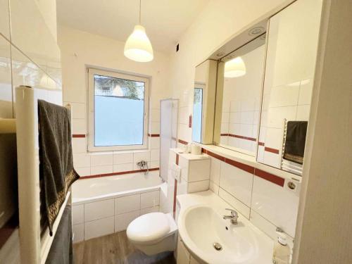 uma casa de banho com um lavatório, uma banheira e um WC. em work & stay apartment em Eitorf