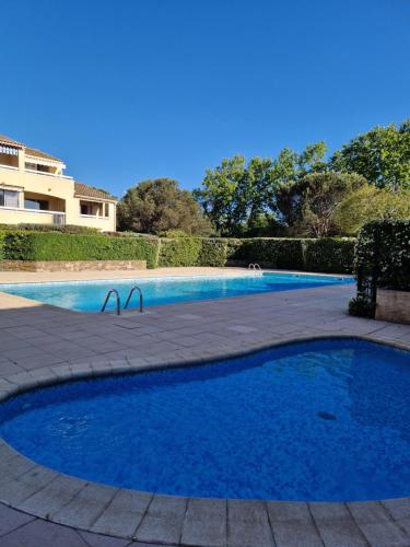 une piscine avec de l'eau bleue dans une cour dans l'établissement Studio mezzanine entier à 5min de la plage et de St tropez, à Cogolin