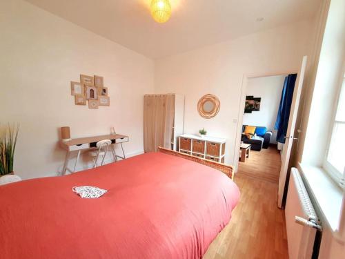 een slaapkamer met een groot rood bed en een bureau bij Le Carillon - hypercentre - WIFI in Douai