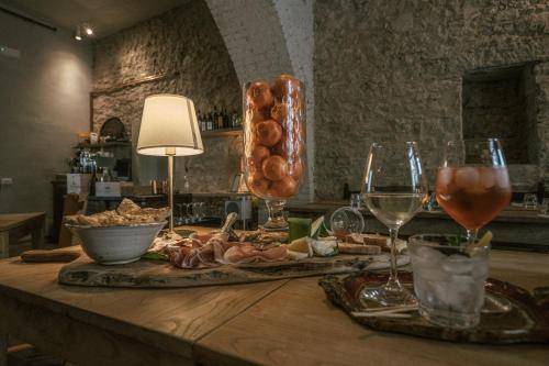 una mesa con copas de vino y comida en ella en Albergo La Pietra, en Roccalbegna