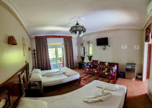 a large bedroom with two beds and a chandelier at Ali Baba Hotel in Dahab