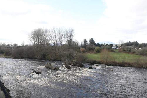 a river with white water and rocks in it at Foxford penthouse in Foxford