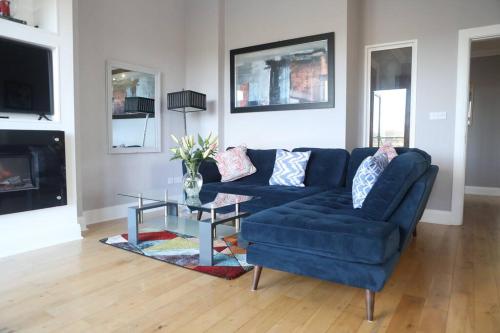 a living room with a blue couch and a table at Luxury Three Bedroom Apartment Foxford County Mayo in Foxford