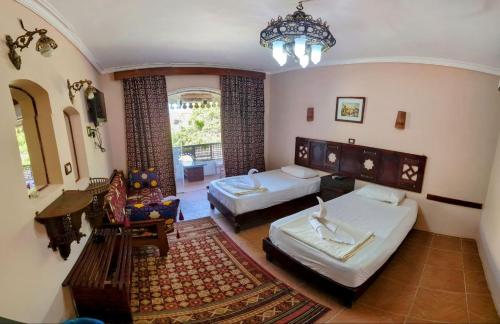 ein Schlafzimmer mit 2 Betten und ein Wohnzimmer in der Unterkunft Ali Baba Hotel in Dahab