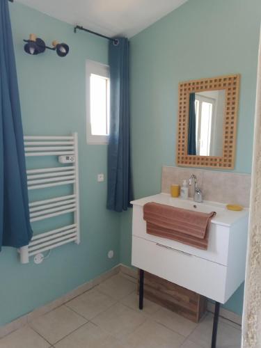 une salle de bain avec un lavabo blanc et un miroir dans l'établissement Mas Pied Blanc, à Saint-Jean-de-Maruéjols-et-Avéjan