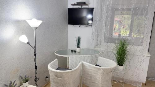 un soggiorno con tavolo, sedie e TV di Agroturystyka a Uniejow