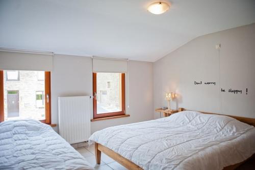 a bedroom with a bed and a writing on the wall at Chez ELoy in Rochehaut