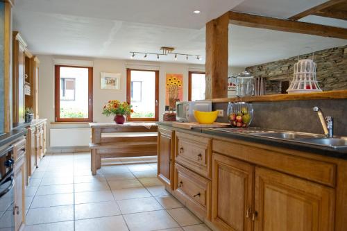 a large kitchen with wooden cabinets and a sink at Chez ELoy in Rochehaut