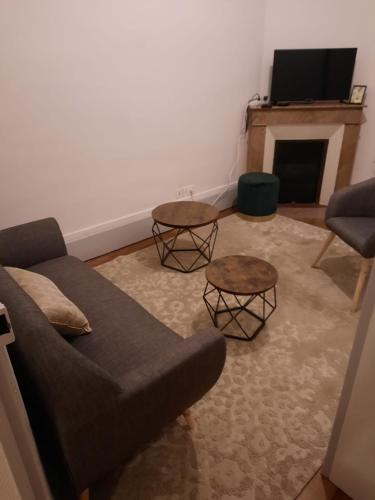 un salon avec un canapé et deux tables dans l'établissement Appartement Jean Paul Sarthe, à Chalon-sur-Saône