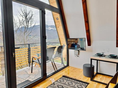 Habitación con una gran puerta de cristal que da a un balcón. en Fern Farm Tiny Home en Mojkovac