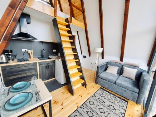 a kitchen and a living room with a spiral staircase at Fern Farm Tiny Home in Mojkovac