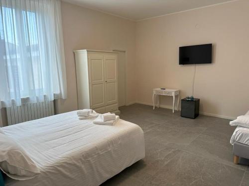 een slaapkamer met een bed en een flatscreen-tv bij Hotel Il Duca barbablu in Sabbioneta