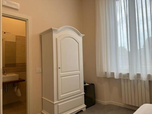 a bathroom with a white cabinet next to a window at Hotel Il Duca barbablu in Sabbioneta