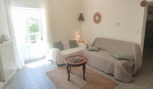 a living room with a couch and a table at T3 avec sa terrasse au cœur du village médiéval in Sauzet