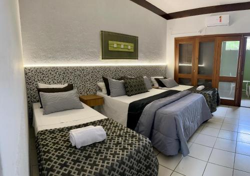 a hotel room with two beds and two beds sidx sidx at Recanto Verde Praia Hotel Juquehy in Juquei