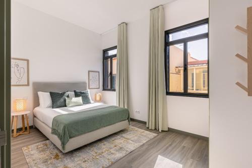 a bedroom with a bed and a window at Fort Bay Suite Apartments in Machico