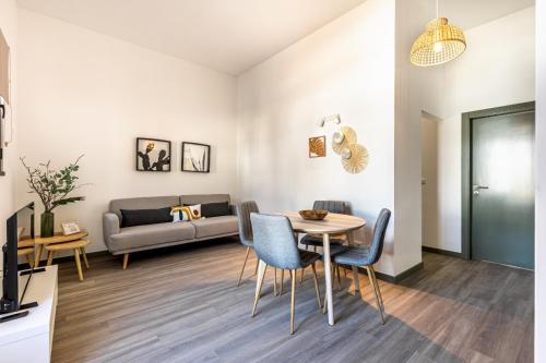 a living room with a table and chairs and a couch at Fort Bay Suite Apartments in Machico