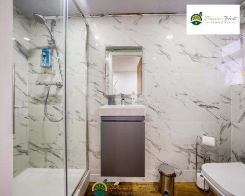 a bathroom with a shower and a sink and a mirror at LOW rate SPECIAL DEAL for a 3 Bedroom house with 2 Baths- near Coventry Community Centre and War Memorial Park with Parking and FREE unlimited Wi-fi - ARC in Coventry