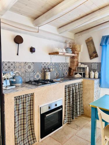 a kitchen with a stove top oven next to a table at I Trulli di Giorgia in Torre Suda