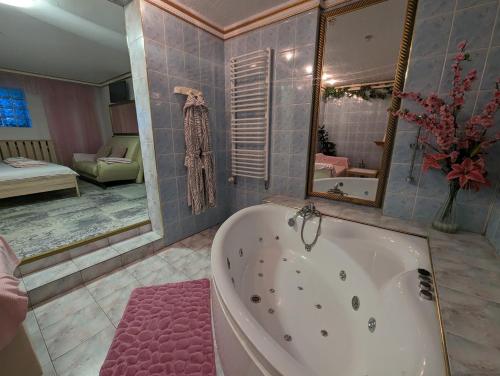 a large bathroom with a tub and a bedroom at Motel DRABEK in Tarnowskie Góry