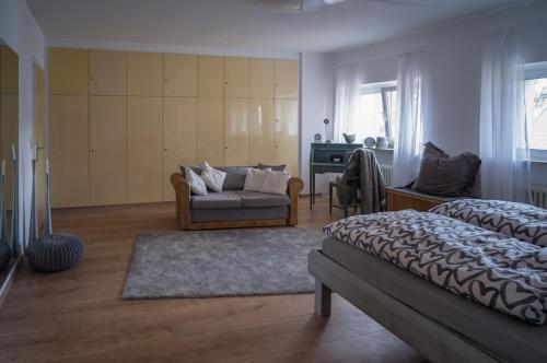 1 dormitorio con cama, sofá y mesa en Ferienwohnung Backes, en Ettringen