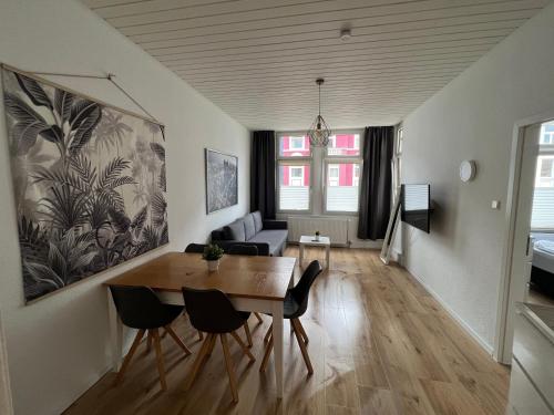 sala de estar con mesa, sillas y sofá en Bilk Apartment, en Düsseldorf
