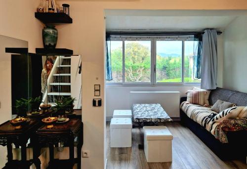 un salon avec un canapé et une fenêtre dans l'établissement Studio mezzanine entier à 5min de la plage et de St tropez, à Cogolin
