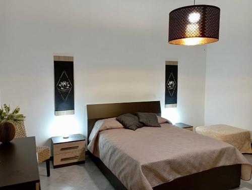 1 dormitorio con 1 cama, 2 mesas y 1 lámpara en A CASA DI GIANNA, en Napola