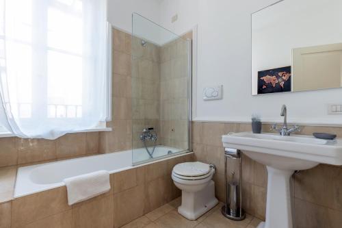 a bathroom with a sink and a toilet and a bath tub at Milan Retreats in Milan
