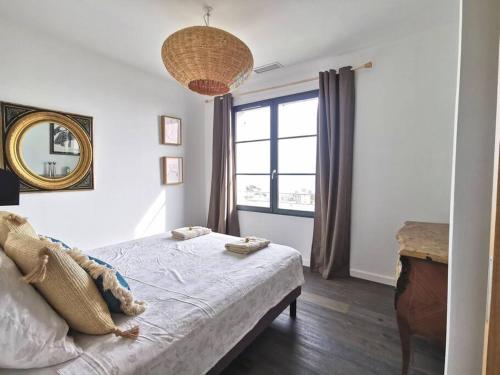 una camera da letto con un letto con specchio e una finestra di Casa Lunga à Erbalunga- A deux pas de la plage a Brando