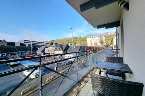a balcony with two chairs and a view of a city at Chez Lou et Dan 4P apartment with balcony elevator and secure parking in Honfleur