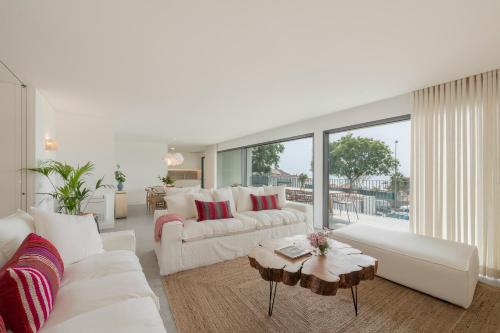 a living room with white furniture and a large window at CASA DO MIRADOURO 5 by Heart of Funchal in Funchal